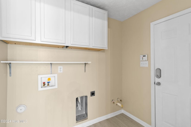 laundry area with cabinets, washer hookup, electric dryer hookup, gas dryer hookup, and a textured ceiling