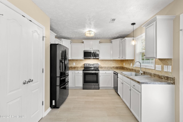 kitchen with decorative backsplash, appliances with stainless steel finishes, sink, decorative light fixtures, and white cabinets