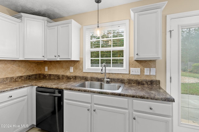 kitchen featuring sink, white cabinets, and hanging light fixtures