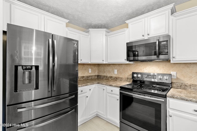 kitchen with white cabinets, appliances with stainless steel finishes, and a textured ceiling