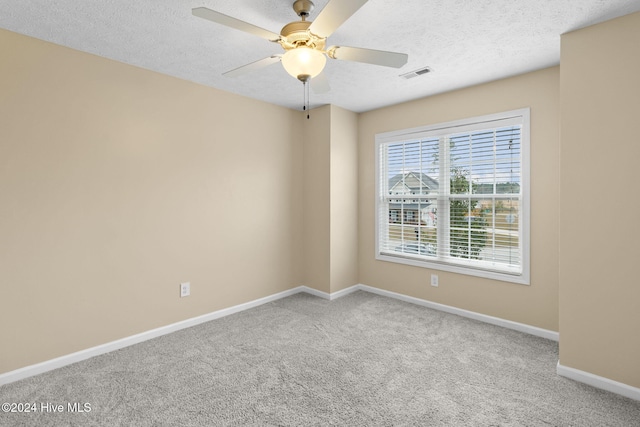 unfurnished room with carpet, ceiling fan, and a textured ceiling