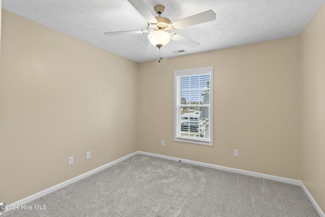 empty room with carpet, ceiling fan, and a textured ceiling