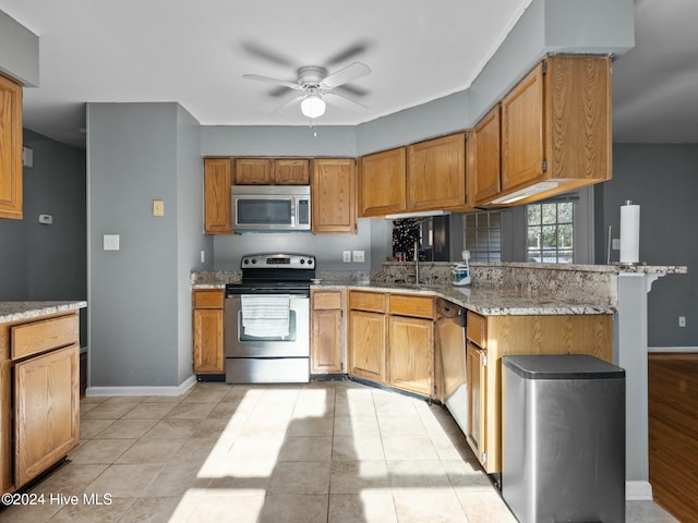 kitchen featuring ceiling fan, light tile patterned floors, light stone counters, kitchen peninsula, and stainless steel appliances