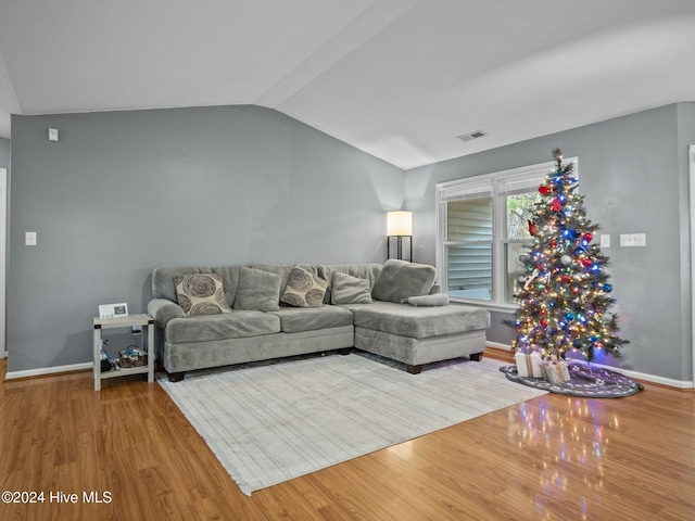 living room with hardwood / wood-style flooring and vaulted ceiling