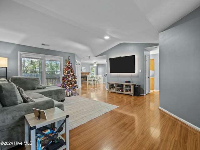 living room with hardwood / wood-style floors, ceiling fan, and lofted ceiling