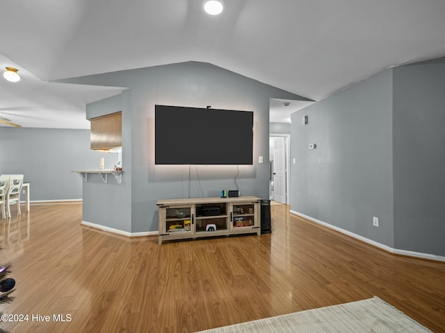 living room featuring light hardwood / wood-style floors and vaulted ceiling