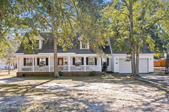 new england style home featuring a porch and a garage