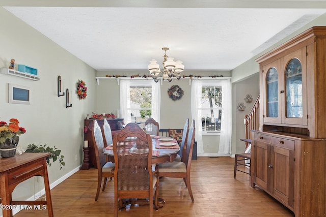 dining room with hardwood / wood-style flooring and an inviting chandelier