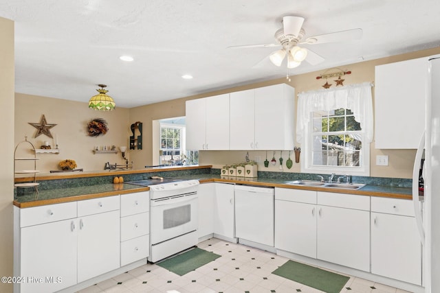 kitchen with ceiling fan, sink, kitchen peninsula, white appliances, and white cabinets