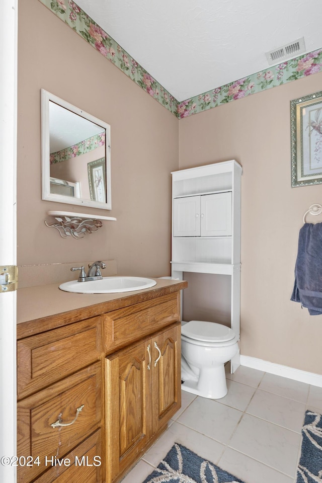 bathroom with tile patterned flooring, vanity, and toilet