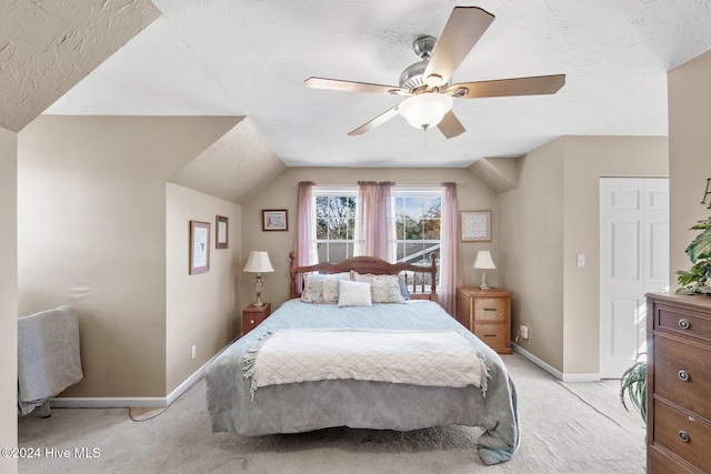 carpeted bedroom with a textured ceiling, ceiling fan, and lofted ceiling