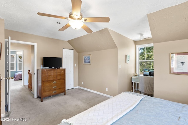 bedroom with light carpet, a textured ceiling, ceiling fan, and lofted ceiling