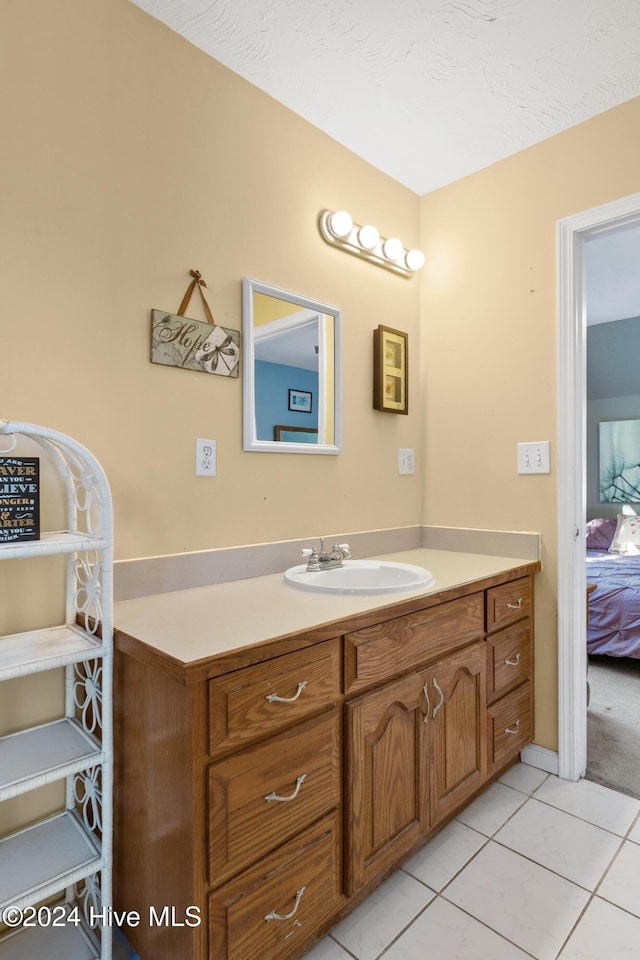 bathroom featuring tile patterned flooring, vanity, and a textured ceiling