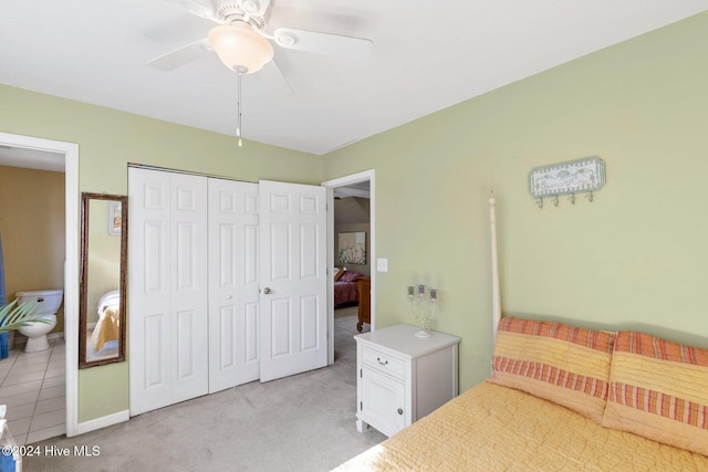 carpeted bedroom featuring a closet, ceiling fan, and ensuite bathroom