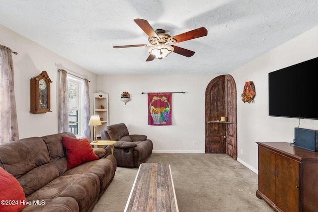 living room with light carpet, a textured ceiling, and ceiling fan