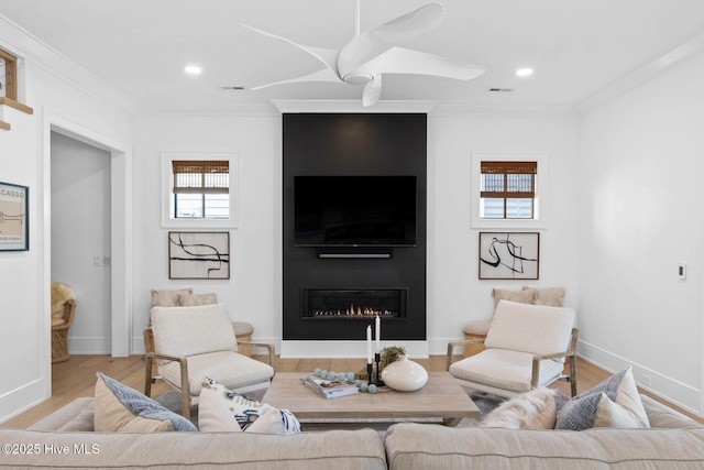 living area featuring a fireplace, crown molding, visible vents, and wood finished floors