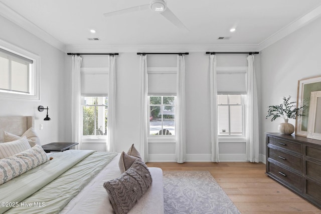 bedroom featuring light wood-type flooring, ceiling fan, crown molding, and visible vents