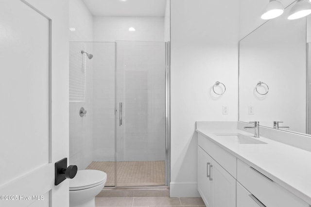 bathroom featuring vanity, toilet, a shower stall, and tile patterned floors