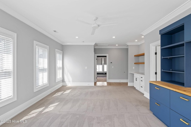 unfurnished living room featuring light colored carpet, plenty of natural light, baseboards, and ornamental molding
