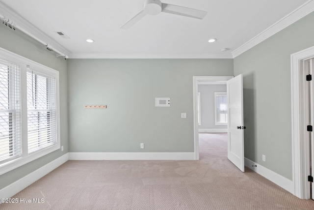 empty room with light carpet, ornamental molding, baseboards, and visible vents