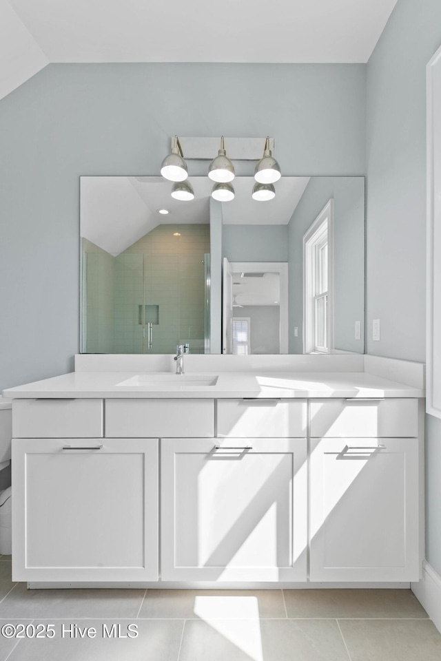 bathroom featuring lofted ceiling, toilet, a shower stall, tile patterned floors, and vanity