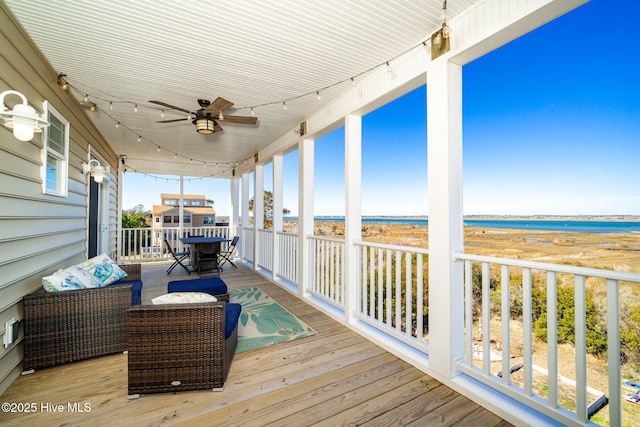 wooden deck with an outdoor hangout area, outdoor dining space, a water view, and a ceiling fan