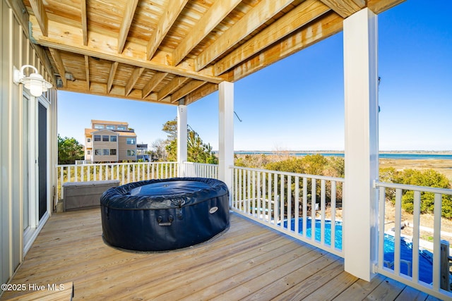 wooden terrace with a hot tub and a fenced in pool