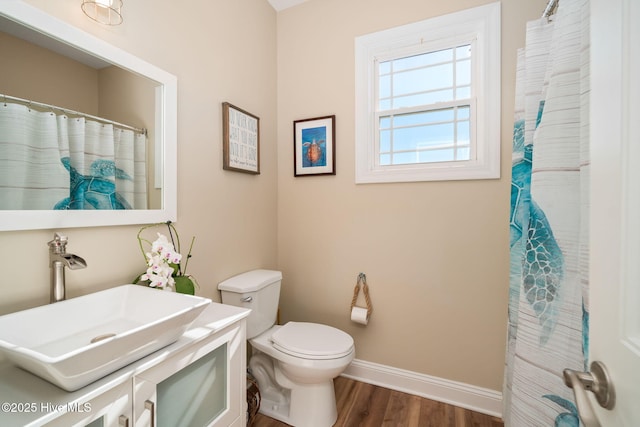 full bathroom with toilet, wood finished floors, vanity, and baseboards