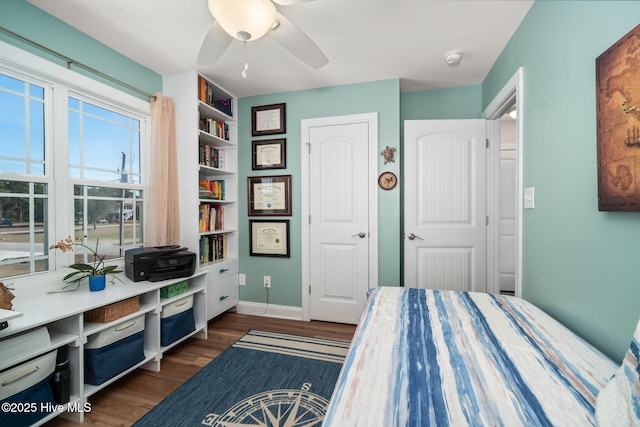 bedroom featuring dark wood-style flooring, a ceiling fan, and baseboards