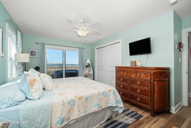 bedroom featuring ceiling fan, a closet, wood finished floors, access to exterior, and baseboards
