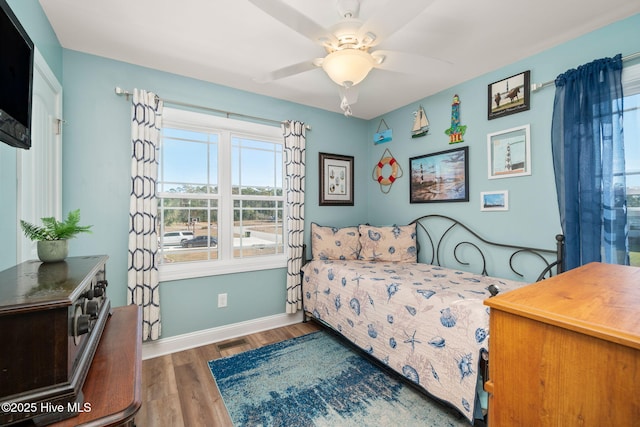 bedroom with ceiling fan, dark wood finished floors, visible vents, and baseboards