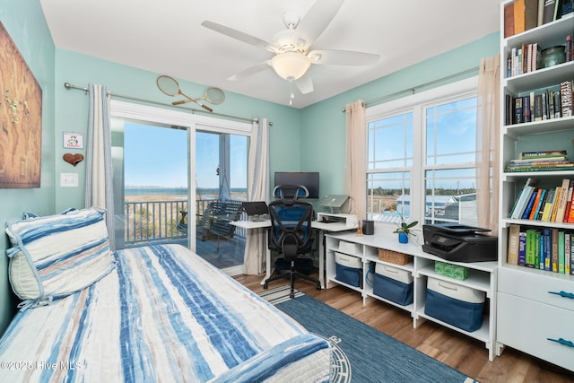 bedroom featuring access to exterior, multiple windows, ceiling fan, and wood finished floors