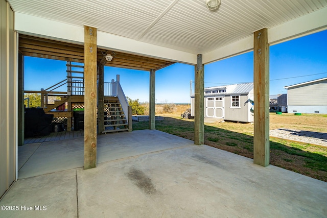 view of patio / terrace with an outbuilding, a storage unit, and stairs