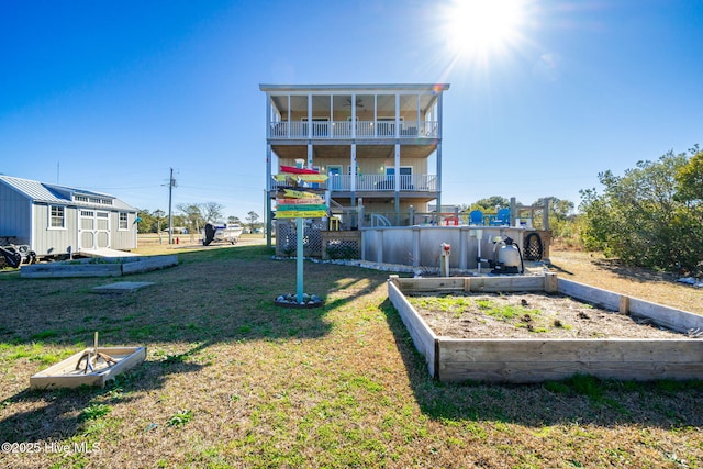 back of house featuring a balcony, an outdoor structure, and a lawn