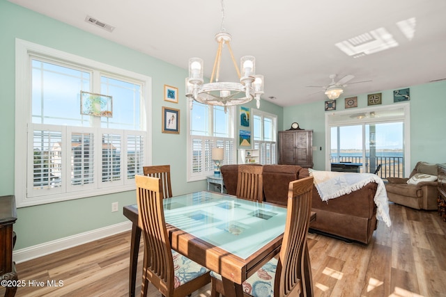 119 E Dr, Harkers Island, NC 28531 - dining space with a chandelier, light wood finished floors, ceiling fan, and baseboards