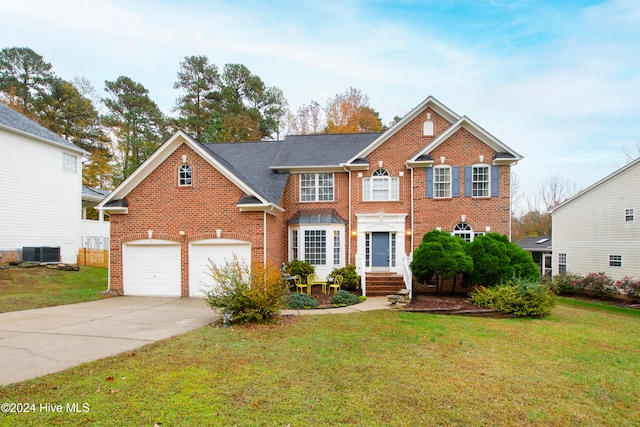 view of front of home featuring a front yard, a garage, and central air condition unit