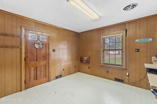 foyer featuring wooden walls