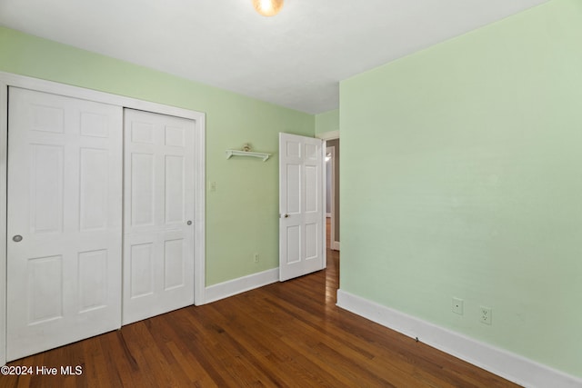 unfurnished bedroom featuring dark hardwood / wood-style floors and a closet