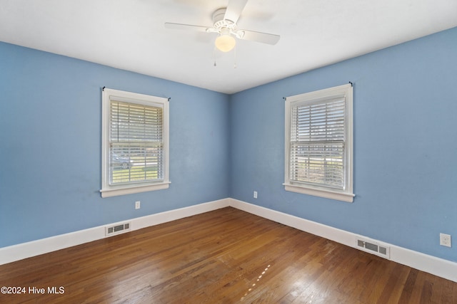 empty room with hardwood / wood-style floors, ceiling fan, and a wealth of natural light