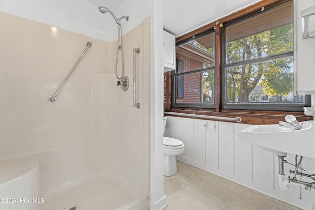 bathroom featuring concrete flooring, toilet, and walk in shower