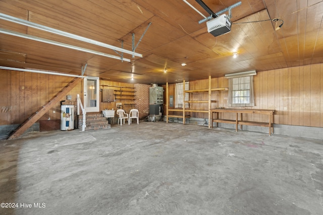 garage with electric water heater, a garage door opener, wooden walls, and wood ceiling