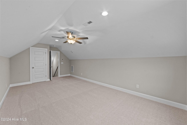 additional living space with ceiling fan, light colored carpet, and vaulted ceiling