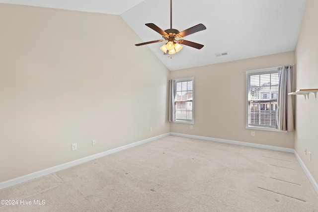 carpeted spare room featuring ceiling fan and lofted ceiling