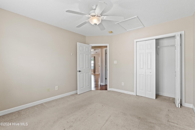 unfurnished bedroom with ceiling fan, a closet, and light colored carpet