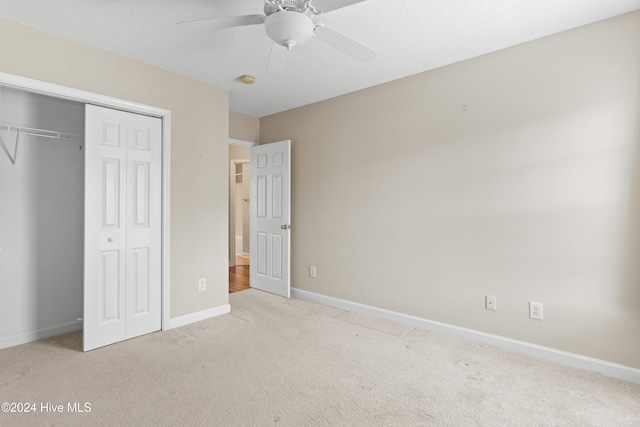 unfurnished bedroom with ceiling fan, a closet, and light colored carpet