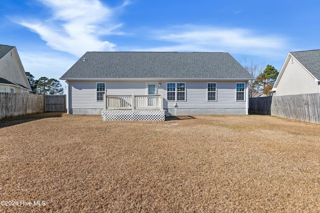 back of house featuring a wooden deck and a yard