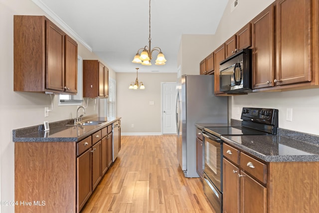 kitchen with pendant lighting, an inviting chandelier, black appliances, sink, and light hardwood / wood-style flooring