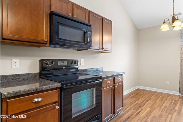 kitchen with vaulted ceiling, black appliances, decorative light fixtures, a chandelier, and light hardwood / wood-style floors