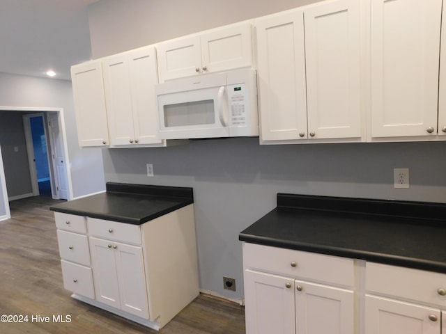 12521 Mckinnon Dr, Laurinburg, NC 28352 - kitchen featuring white microwave, dark countertops, white cabinetry, and recessed lighting
