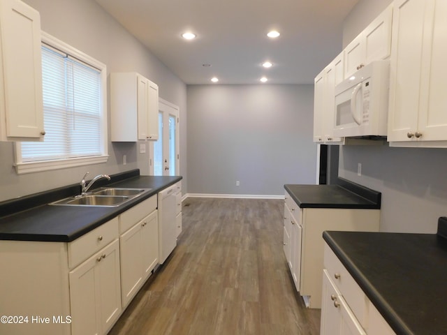 12521 Mckinnon Dr, Laurinburg, NC 28352 - kitchen with white appliances, dark countertops, recessed lighting, wood finished floors, and white cabinetry
